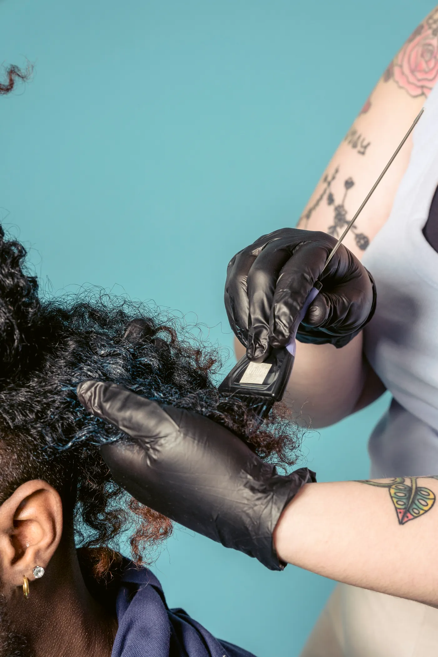 Application d’une coloration au pinceau sur cheveux bouclés