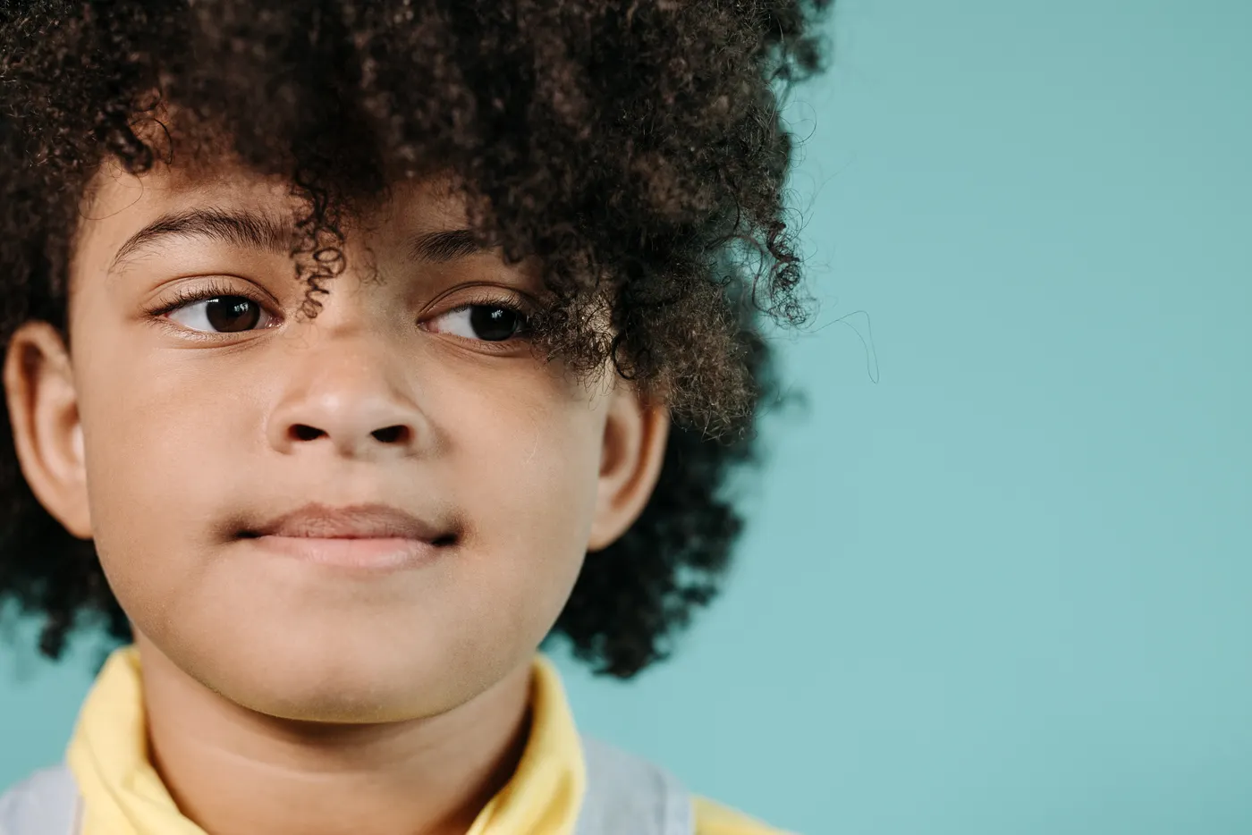 Portrait rapproché d’un enfant aux cheveux bouclés coiffés
