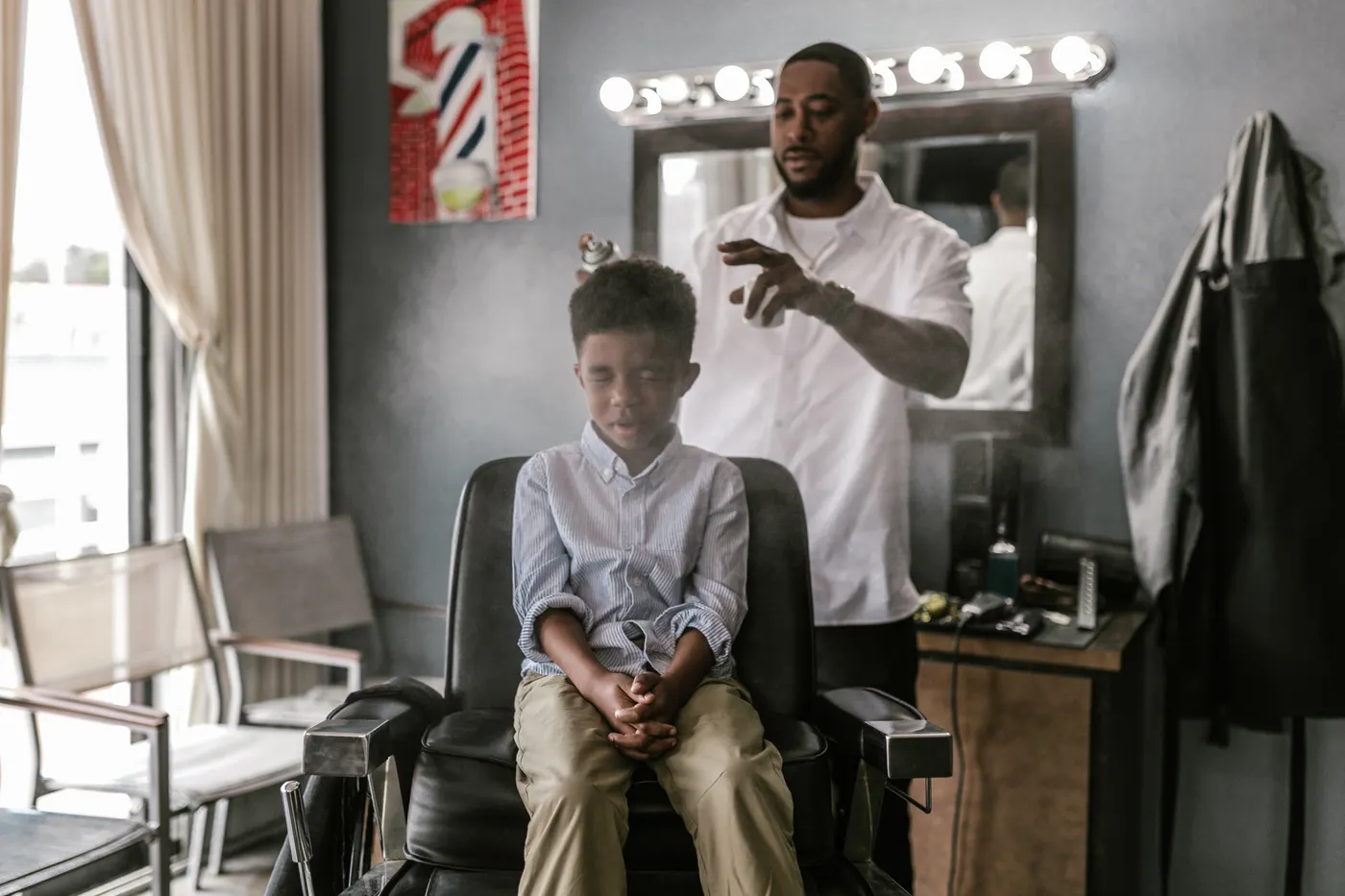 Coupe d’un garçon en cours au salon, finitions à la tondeuse