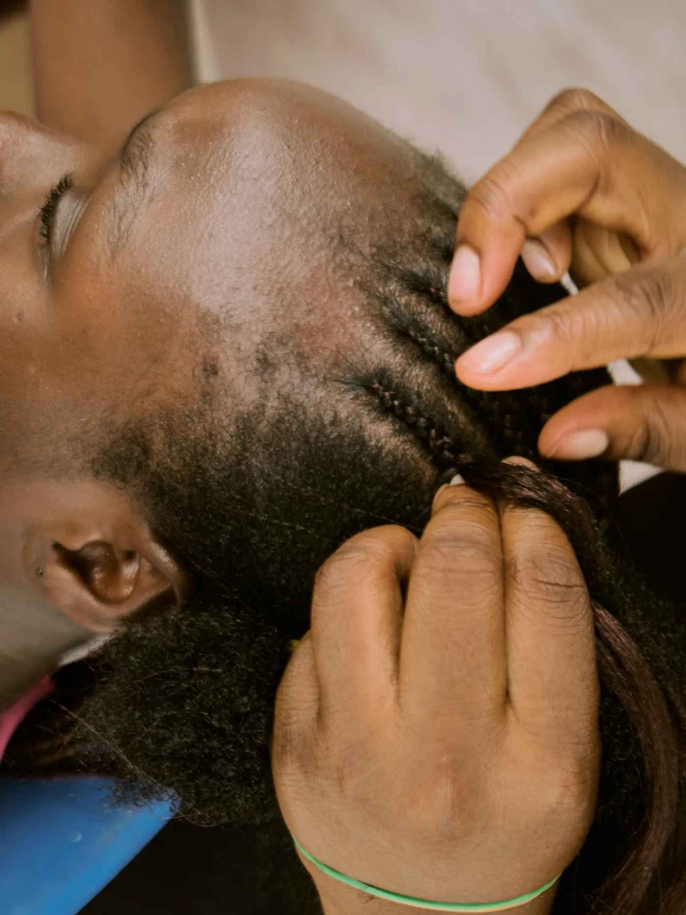 Mains d’une coiffeuse en train de tresser